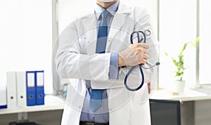 Doctor standing in office with stethoscope in hand