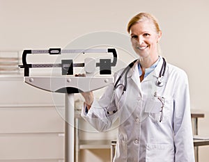 Doctor standing with weighing scales