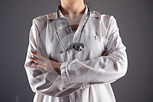 a doctor with a stethascope stands crossed hands photo