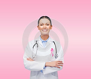 Doctor with stethoscope, cancer awareness ribbon