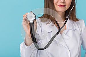 Doctor with stethoscope, close up over blue background