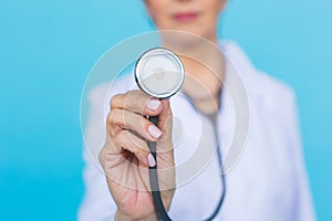 Doctor with stethoscope, close up over blue background