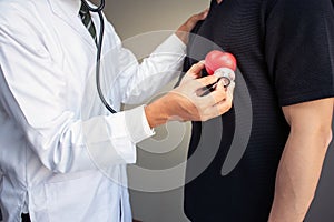 Doctor with stethoscope examining red heart,Health concept