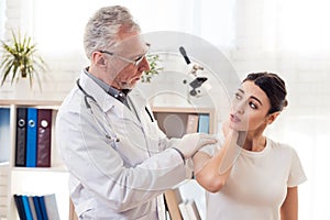 Doctor with stethoscope and female patient in office. Doctor is examining woman`s back.