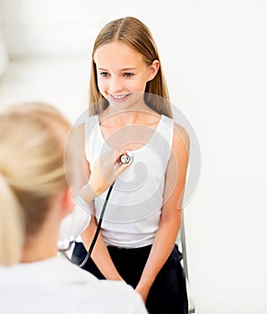 Doctor with stethoscope and girl at hospital