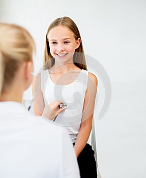 Doctor with stethoscope and girl at hospital