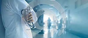 Doctor with stethoscope in hand on hospital background photo