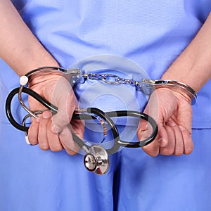 Doctor with stethoscope in handcuffs