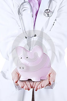 Doctor with Stethoscope Holding Piggy Bank