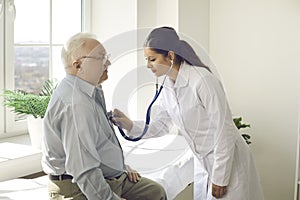 Doctor with stethoscope listen elderly male patient heartbeat at hospital ward