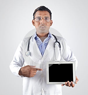 Doctor with stethoscope pointing finger to the blank tablet pc s