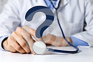 Doctor with stethoscope and question mark. medical advice, health care confusion and faq concept