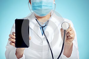 Doctor with stethoscope and smart phone in hand for medical exam concepts