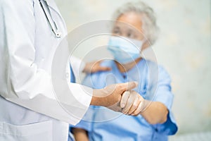 Doctor with stethoscope to checking Asian senior or elderly old lady woman patient wearing a face mask in hospital for protect