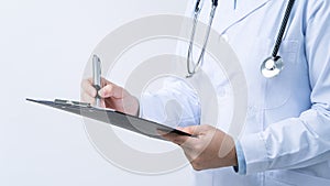 Doctor with stethoscope in white coat holding clipboard, writing medical record diagnosis, isolated on white background, close up