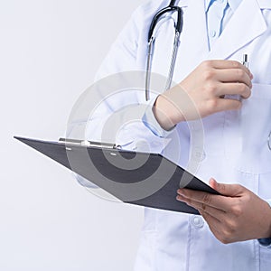 Doctor with stethoscope in white coat holding clipboard, writing medical record diagnosis, isolated on white background, close up