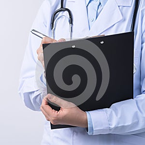 Doctor with stethoscope in white coat holding clipboard, writing medical record diagnosis, isolated on white background, close up