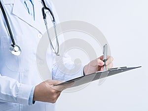 Doctor with stethoscope in white coat holding clipboard, writing medical record diagnosis, isolated on white background, close up