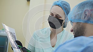 Doctor stomatologist and patient in the dental office, consulting, explanation and demonstration of x-ray