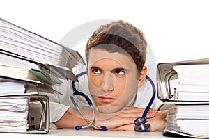 Doctor on stress with stacks of files. Bureaucracy photo