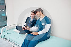 Doctor, students and break on phone on a hospital, healthcare and clinic bed with social media. Media, mobile and happy