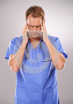 Doctor, studio and headache for stress, burnout or tension and stethoscope. Man, worry or migraine for professional