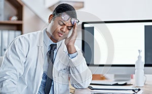 Doctor suffering from headache, stress and pain while working in a hospital. Young, tired health care professional
