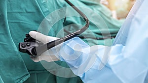 A doctor or surgeon in a light blue protective gown did a colonoscopy or gastroscopy inside operating theatre in the hospital.