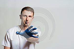 Doctor surgeon with needle holder in medical gloves on white background. Plastic surgery advert.