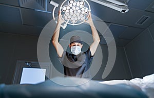 Doctor surgeon in the operating room with lamp
