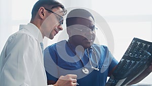 Doctor and surgeon talking near window. Medical workers in hospital office. Day light. Healthcare, medicine, teamwork.