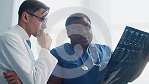 Doctor and surgeon talking near window. Medical workers in hospital office. Day light. Healthcare, medicine, teamwork.