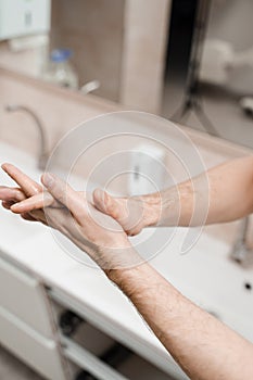 Doctor surgeon is washing hands before surgery in medical clinic. Hygiene. Correct hand washing with soap, gel and water