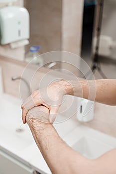 Doctor surgeon is washing hands before surgery in medical clinic. Hygiene. Correct hand washing with soap, gel and water