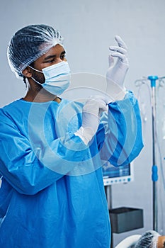 Doctor in surgery, man in healthcare and surgical procedure start with PPE for safety in operation theatre in hospital