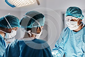 Doctor, surgery and operating room with face mask for medical emergency, operation or hospital. People, teamwork and