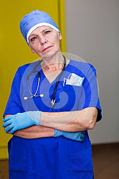 A doctor in a surgical cap wearing blue gloves and stethoscope