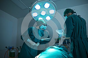 Doctor surgical are discussing. The surgeon team is working in the operating room. The surgeon is saving the patient`s life