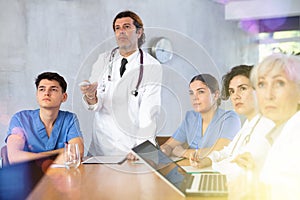 Doctor switching slides of presentation during medical consultation with colleagues