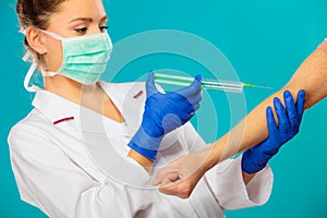 Doctor with syringe giving injection to patient.