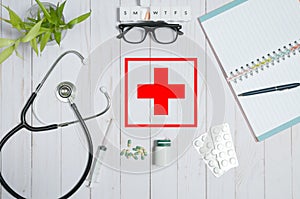 Doctor table with medical items, stethoscope and pills