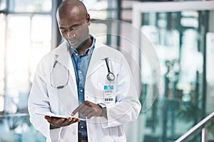 Doctor with tablet, happy reading social media post, text or email from on break at hospital. Black man in healthcare