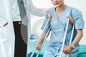 Doctor takes care of patient in crutch at hospital