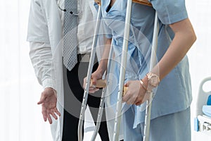 Doctor takes care of patient in crutch at hospital