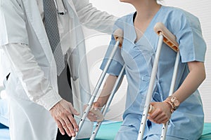 Doctor takes care of patient in crutch at hospital