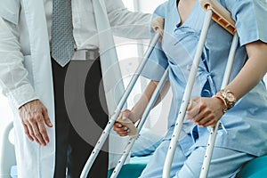 Doctor takes care of patient in crutch at hospital