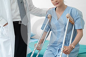Doctor takes care of patient in crutch at hospital