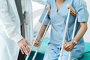 Doctor takes care of patient in crutch at hospital