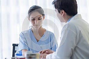 A doctor takes care of a sick patient woman with sadness and unhappiness at the hospital or medical clinic