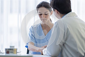 A doctor takes care of a sick patient woman with sadness and unhappiness at the hospital or medical clinic